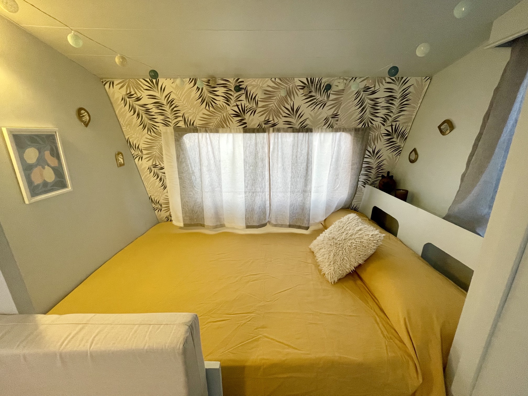 Cama con sábanas amarillas y luz de mañana