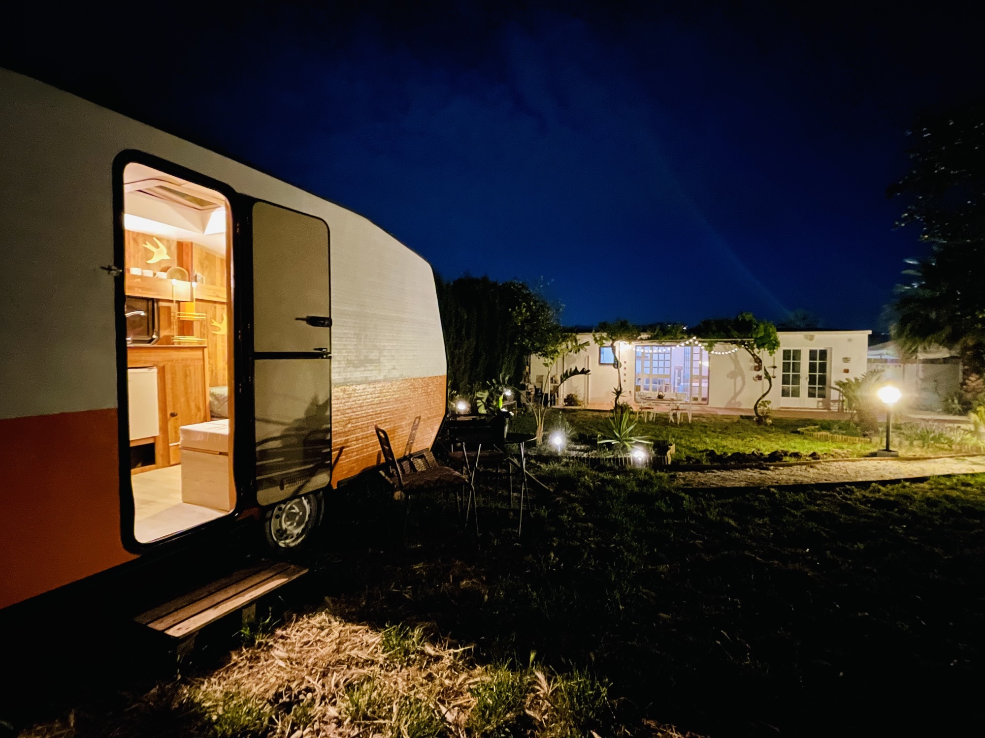 Caravana iluminada de noche — tu refugio privado